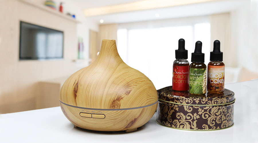 Three Condar scents and diffuser with a blurred living room behind them.